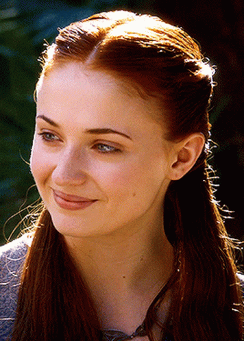 A Close Up Of A Woman 'S Face With Long Red Hair GIF