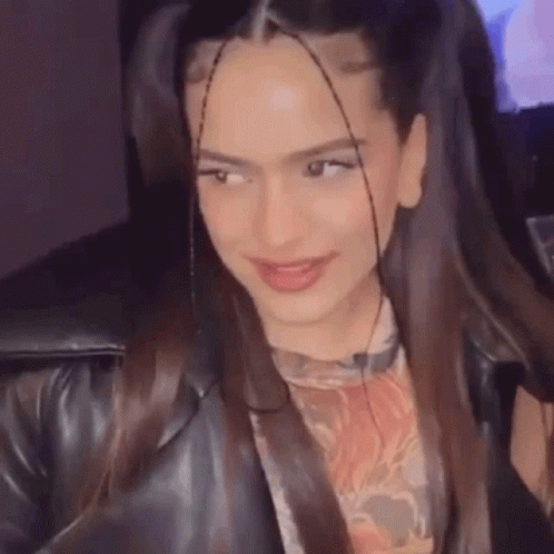 A Close Up Of A Woman 'S Face With Pigtails And A Leather Jacket On . GIF