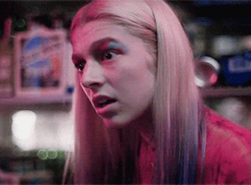 A Close Up Of A Woman 'S Face With Pink And Blue Makeup GIF
