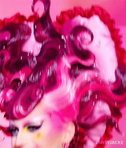 A Close Up Of A Woman 'S Face With Pink Hair GIF