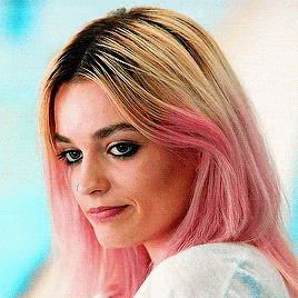 A Close Up Of A Woman 'S Face With Pink Hair GIF