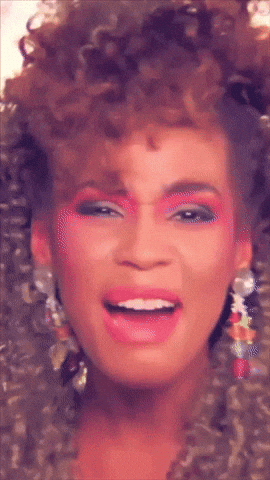 a close up of a woman 's face with pink makeup and earrings