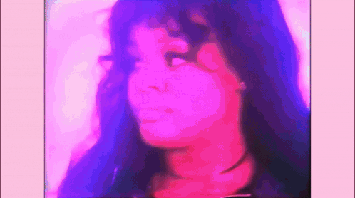 A Close Up Of A Woman 'S Face With Purple And Pink Lighting Behind Her . GIF
