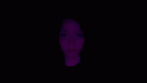 a close up of a woman 's face with purple lights behind her .