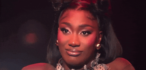 A Close Up Of A Woman 'S Face With Red Eye Shadow GIF