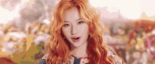 a close up of a woman 's face with red hair and a floral dress .
