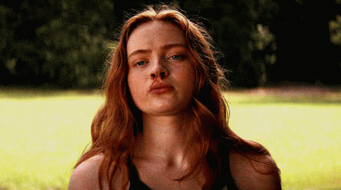 A Close Up Of A Woman 'S Face With Red Hair And Blue Eyes GIF