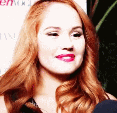 A Close Up Of A Woman 'S Face With Red Hair And Pink Lips GIF