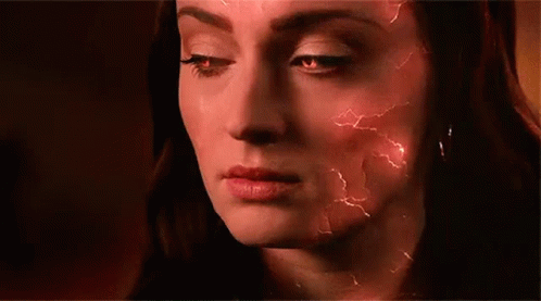 A Close Up Of A Woman 'S Face With Red Lightning Bolts Coming Out Of It . GIF