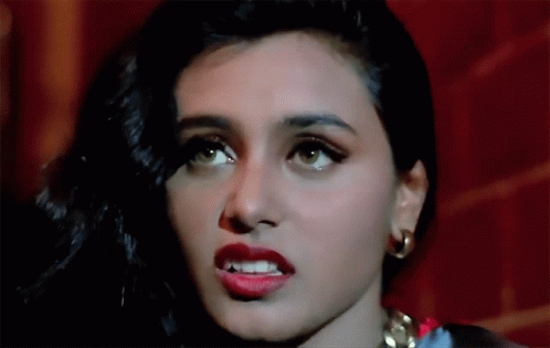 A Close Up Of A Woman 'S Face With Red Lips And Gold Earrings GIF