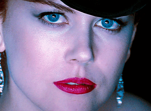 A Close Up Of A Woman 'S Face With Red Lipstick And Blue Eyes GIF