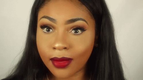 A Close Up Of A Woman 'S Face With Red Lipstick And Long Black Hair . GIF