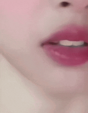 A Close Up Of A Woman 'S Face With Red Lipstick And White Teeth GIF