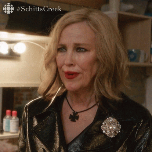 A Close Up Of A Woman 'S Face With #Schitts Creek Written On The Bottom GIF