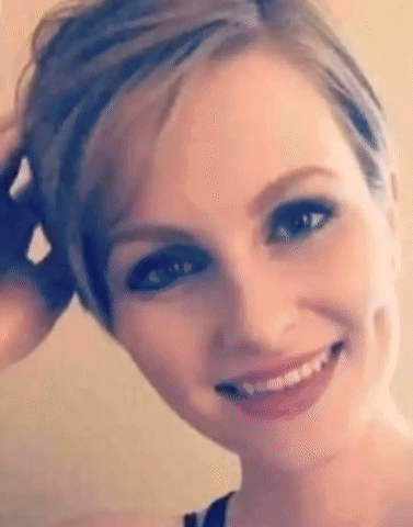 A Close Up Of A Woman 'S Face With Short Hair And A Smile On Her Face . GIF