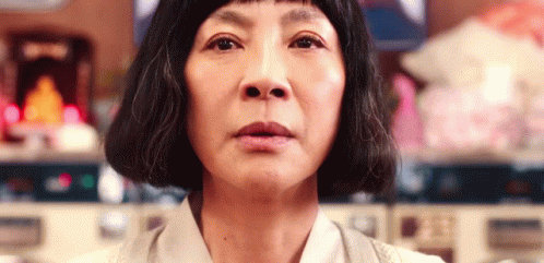 A Close Up Of A Woman 'S Face With Short Hair Looking At The Camera . GIF