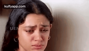 A Close Up Of A Woman 'S Face With Tears Coming Out Of Her Eyes . GIF