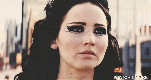 A Close Up Of A Woman 'S Face With The Hashtag #Catchingfire On It GIF