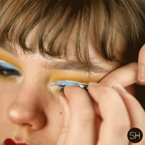 A Close Up Of A Woman 'S Face With The Letters Sh On The Bottom Right GIF