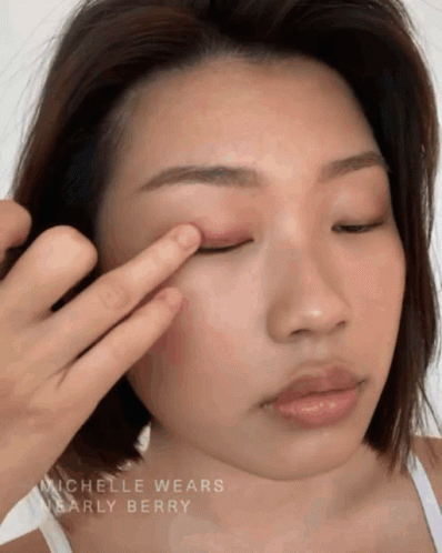 A Close Up Of A Woman 'S Face With The Name Michelle Wears Nearly Berry On The Bottom GIF