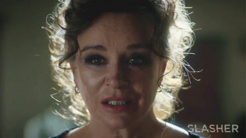 A Close Up Of A Woman 'S Face With The Word Slasher Behind Her GIF