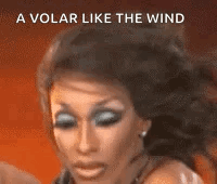 A Close Up Of A Woman 'S Face With The Words `` A Volar Like The Wind '' Behind Her . GIF