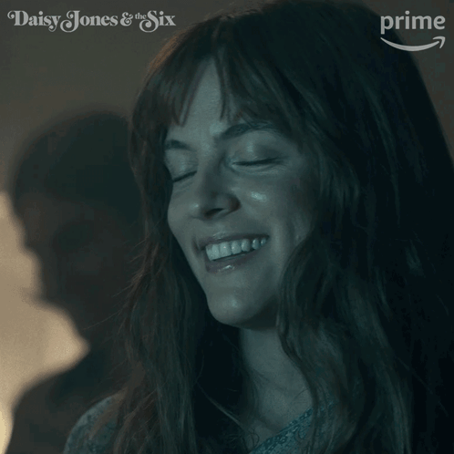 A Close Up Of A Woman 'S Face With The Words Daisy Jones & The Six On The Bottom GIF