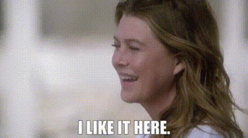 A Close Up Of A Woman 'S Face With The Words `` I Like It Here '' Written On It . GIF