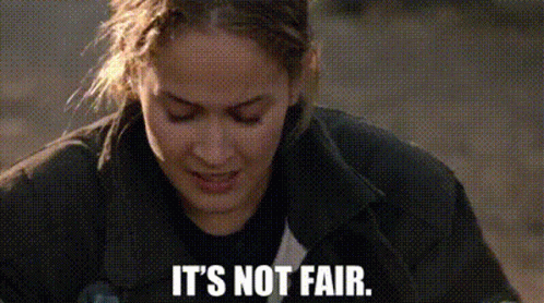 a close up of a woman 's face with the words `` it 's not fair '' written below her .