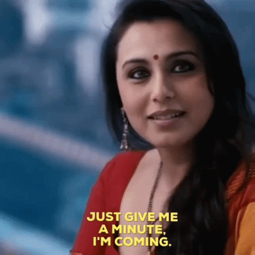 A Close Up Of A Woman 'S Face With The Words `` Just Give Me A Minute , I 'M Coming '' GIF