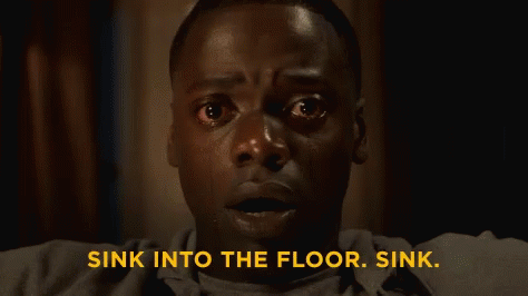 A Close Up Of A Woman 'S Face With The Words `` Sink Into The Floor . Sink '' Written Above Her . GIF