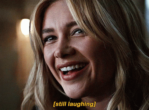 A Close Up Of A Woman 'S Face With The Words Still Laughing Below Her GIF