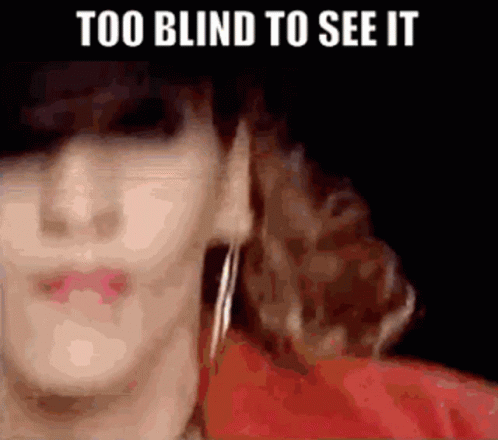 A Close Up Of A Woman 'S Face With The Words `` Too Blind To See It '' Above Her . GIF