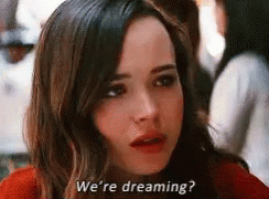 A Close Up Of A Woman 'S Face With The Words `` We 'Re Dreaming '' Written On The Bottom . GIF