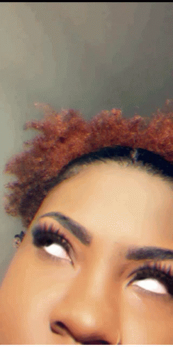 A Close Up Of A Woman 'S Face With White Eyes And Red Hair GIF