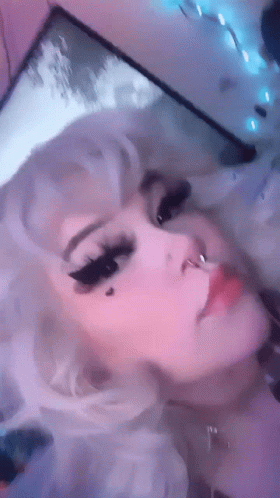 A Close Up Of A Woman 'S Face With White Hair And A Nose Ring GIF