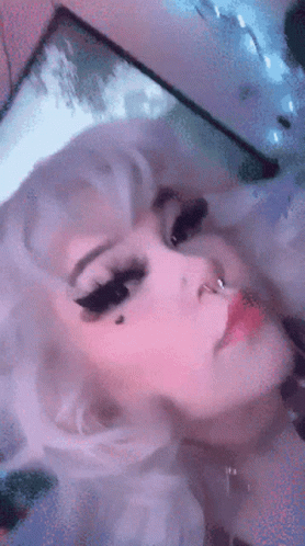A Close Up Of A Woman 'S Face With White Hair And A Nose Ring GIF