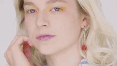 A Close Up Of A Woman 'S Face With Yellow Eye Shadow On . GIF