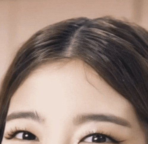 A Close Up Of A Woman 'S Forehead With Long Hair GIF