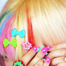 A Close Up Of A Woman 'S Hair With Colorful Hair Clips GIF