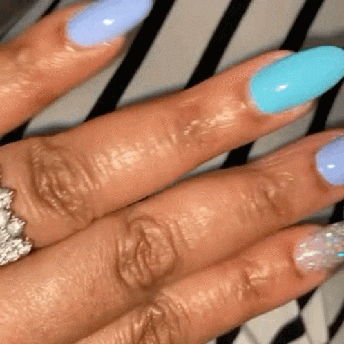 A Close Up Of A Woman 'S Hand With Long Nails And A Ring On Her Finger . GIF
