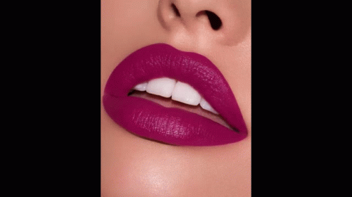 A Close Up Of A Woman 'S Lips With Purple Lipstick And The Words Kisses Below GIF