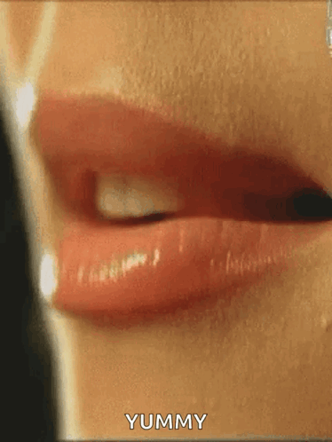 A Close Up Of A Woman 'S Lips With The Words Yummy Written On The Bottom . GIF