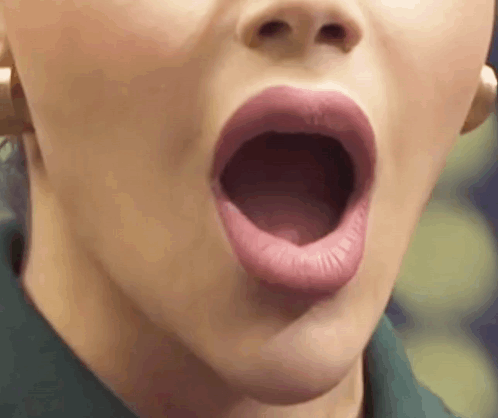A Close Up Of A Woman 'S Mouth With Her Mouth Open And Her Tongue Sticking Out . GIF