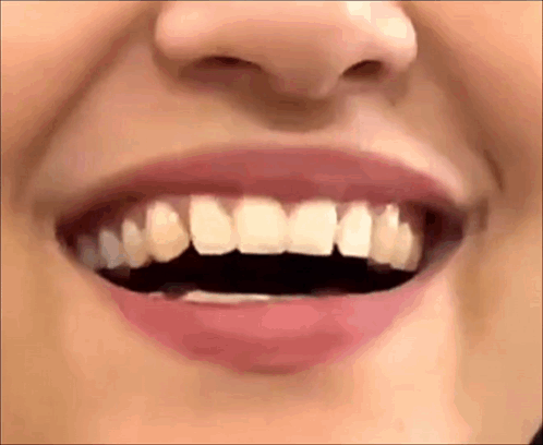 A Close Up Of A Woman 'S Mouth With Her Teeth Visible . GIF