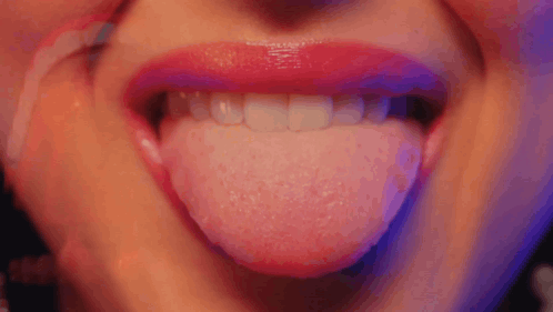 A Close Up Of A Woman 'S Mouth With Her Tongue Out GIF
