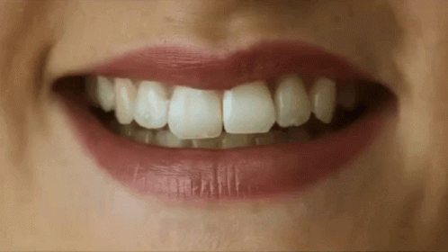 A Close Up Of A Woman 'S Mouth With Red Lips And White Teeth GIF