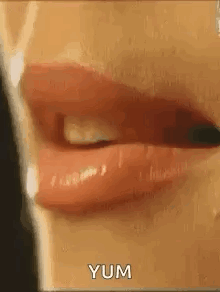 a close up of a woman 's mouth with red lipstick and the words yum written on it .