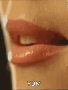 A Close Up Of A Woman 'S Mouth With Red Lipstick And The Words Yum Written On The Bottom . GIF