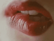 A Close Up Of A Woman 'S Mouth With Red Lipstick And White Teeth . GIF